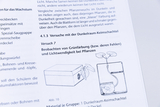 Ein Ausschnitt aus einem Lehrbuch zeigt eine Anleitung zum Versuch mit einer Dunkelraum-Keimschachtel. Gezeigt werden Textpassagen sowie schematische Zeichnungen zum Pflanzenwachstum und zur Grünfärbung.